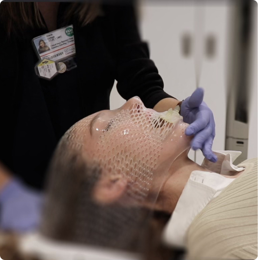 Nurse setting up Stentra in a patient's mouth before radiation treatment